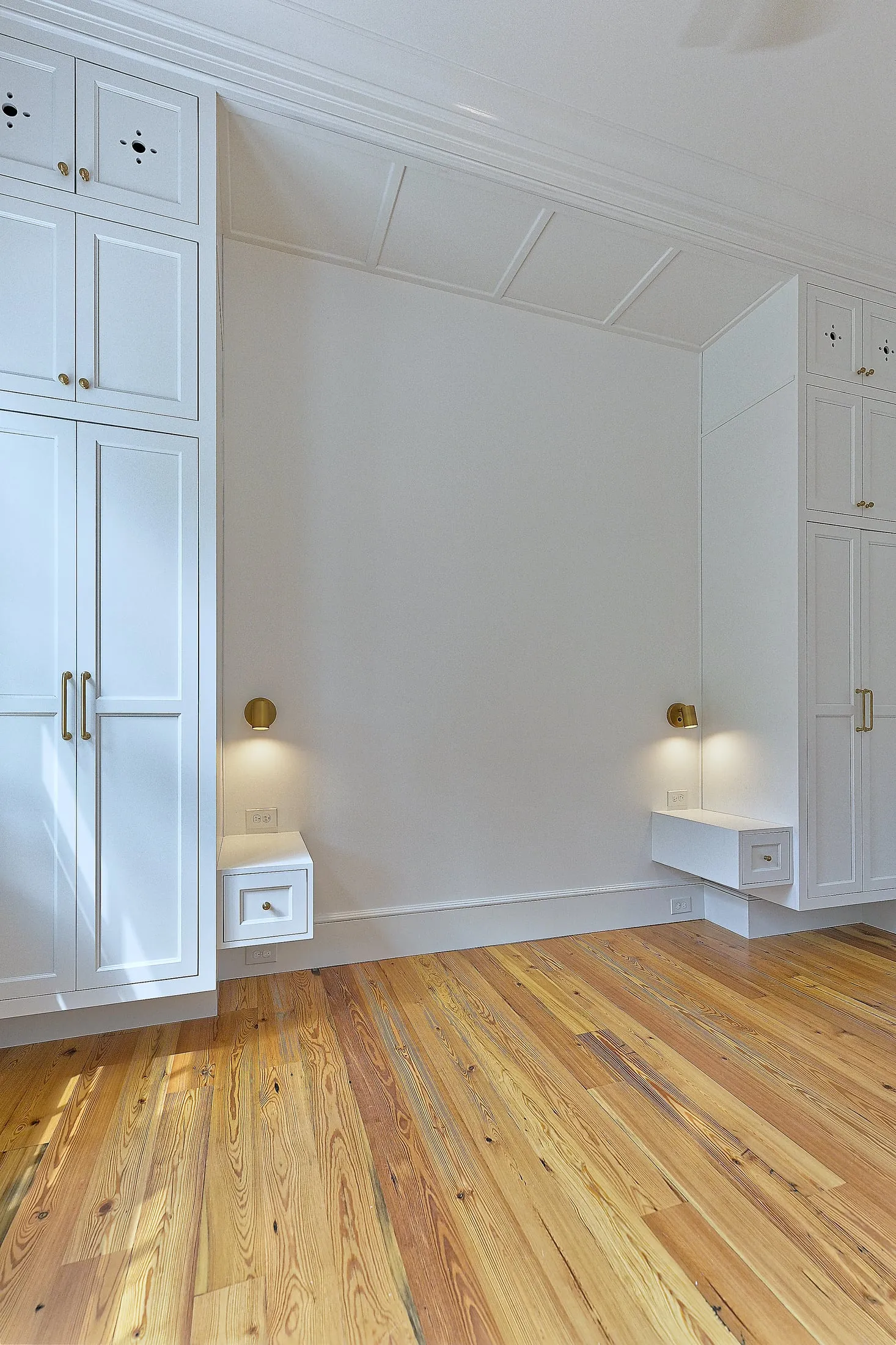 Tall built-in armoire with paneled doors and a floating drawer beside it.